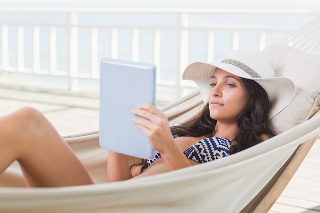 Jolie brune se détendre sur un hamac et à l&#39;aide de tablet pc