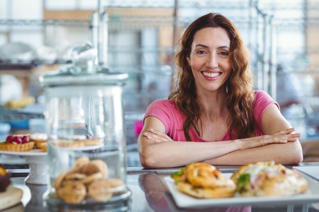 Jolie brune souriante à la caméra derrière le comptoir