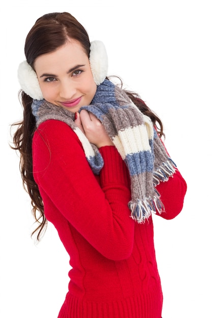 Photo jolie brune en vêtements d'hiver en souriant à la caméra