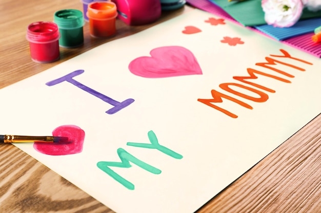 Jolie carte faite à la main avec texte J'AIME MA MAMAN sur table en bois Célébration de la fête des mères