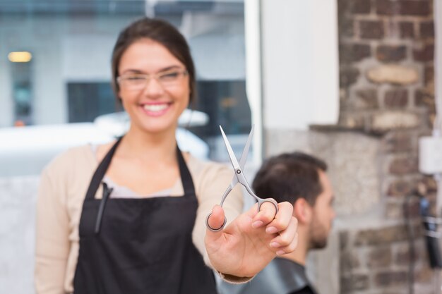 Jolie coiffeuse, souriant à la caméra