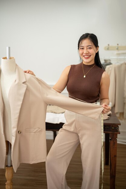Une jolie couturière travaille dans son atelier en vérifiant le motif de son costume sur un mannequin de couturier.
