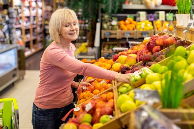 Jolie dame âgée faisant des courses au supermarché