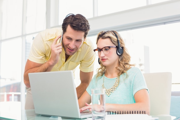 Jolie designer avec casque travaillant sur ordinateur