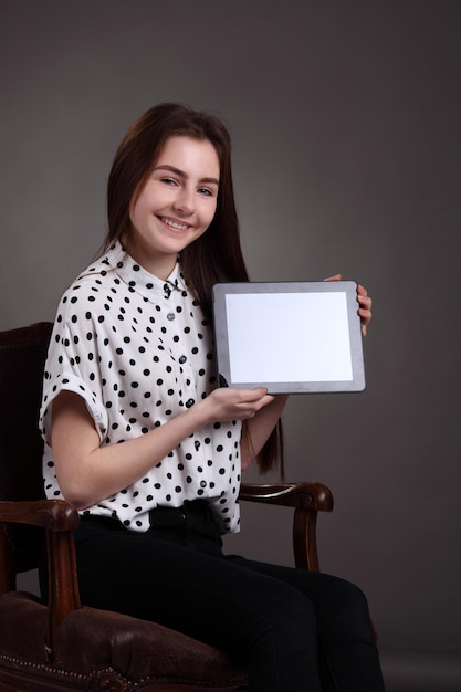 Jolie écolière tenant un tablet pc nouvellement lancé Surfer sur le net
