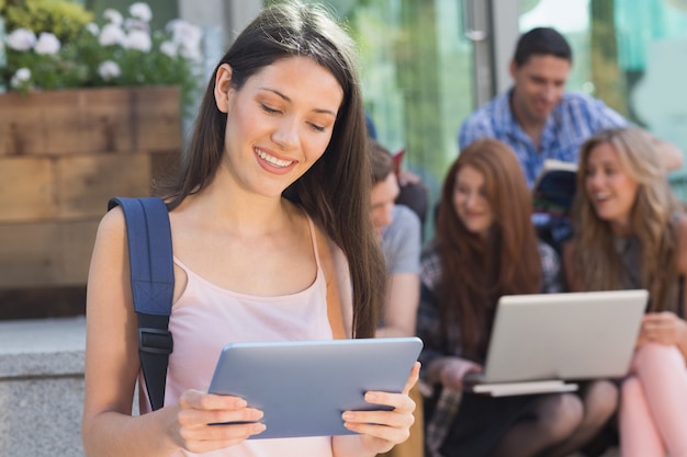 Jolie étudiante à l&#39;aide de son tablet pc sur le campus