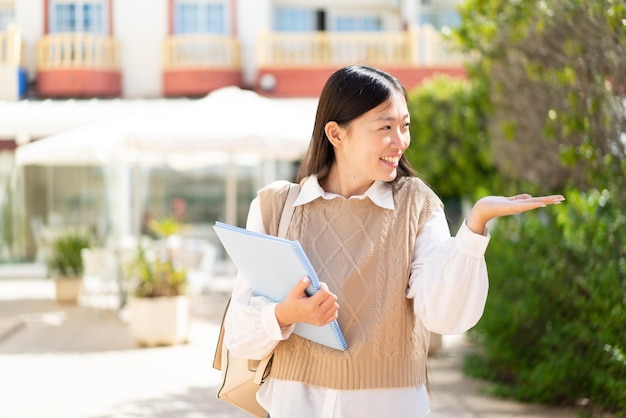 Jolie étudiante chinoise à l'extérieur avec une expression faciale surprise