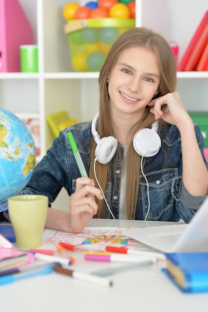 Jolie étudiante en classe avec ordinateur portable et thé