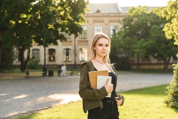 Jolie étudiante marchant dans le parc de l'université