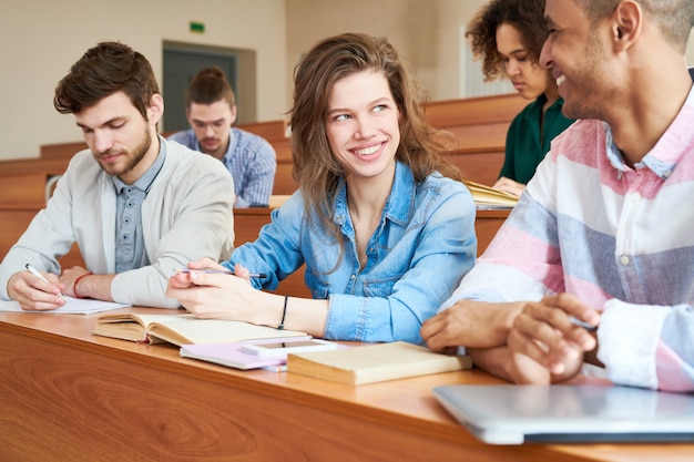 Jolie étudiante parler à son camarade de classe en classe