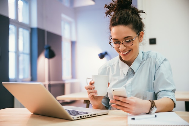 Photo jolie étudiante vérifiant le téléphone