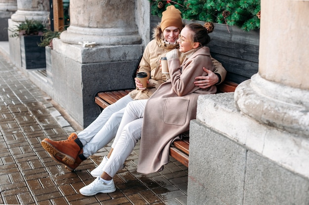 Jolie fashion sensuelle couple élégant amoureux assis sur le banc dans la rue en hiver, s&#39;amuser ensemble