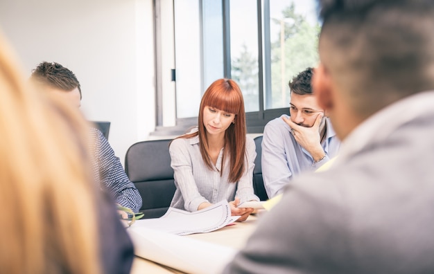 Jolie femme d'affaires au travail - Les gens d'affaires ayant une réunion du conseil d'administration dans un bureau moderne - Équipe de gestionnaires de remue-méninges dans une startup