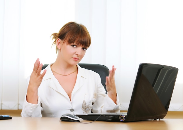 Jolie femme d'affaires brune blanche caucasienne travaillant sur ordinateur portable