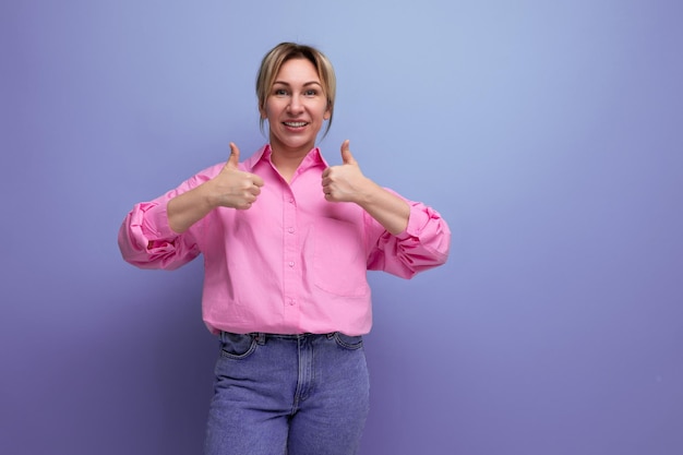 Une jolie femme d'affaires en chemise rose pointant du doigt une petite idée d'entreprise sur le fond du studio avec