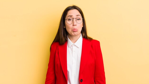 jolie femme d'affaires contre le mur jaune