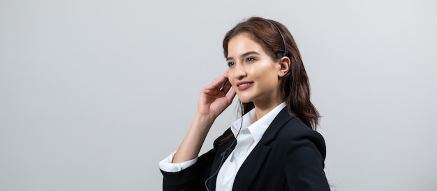 Jolie femme d'affaires en costume et casque souriant tout en travaillant isoler