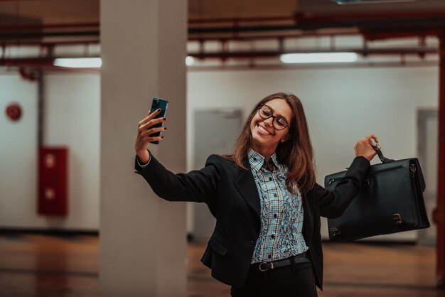 Jolie femme d'affaires en costume une mallette prenant une photo pour les réseaux sociaux avec un smartphone Mise au point sélective