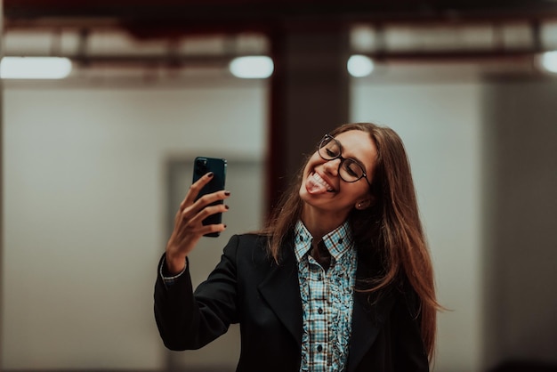 Une jolie femme d'affaires dans des verres à l'aide d'un smartphone. Mise au point sélective. Portrait d'entreprise. Photo de haute qualité