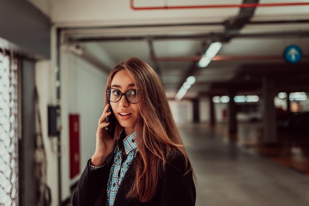 Une jolie femme d'affaires dans des verres à l'aide d'un smartphone. Mise au point sélective. Portrait d'entreprise. Photo de haute qualité