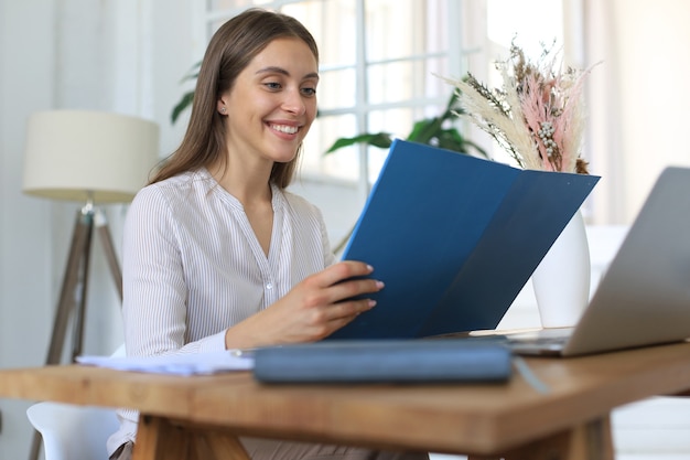 Jolie femme d'affaires joyeuse travaillant au bureau.