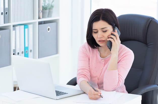 Jolie femme d'affaires parlant au téléphone