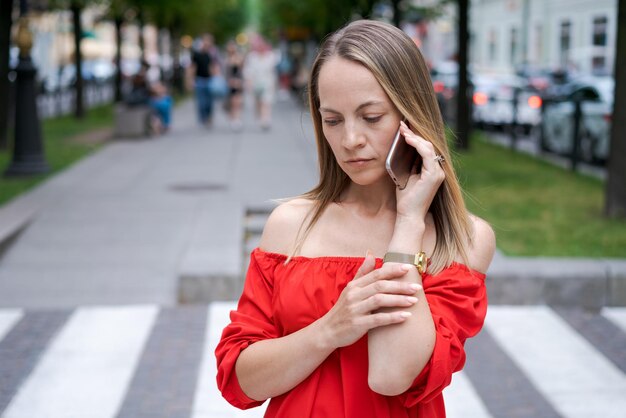 Jolie femme d'affaires parlant sur un téléphone portable avec un client debout