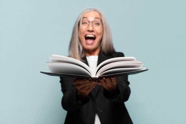 Jolie femme d'affaires senior avec un livre