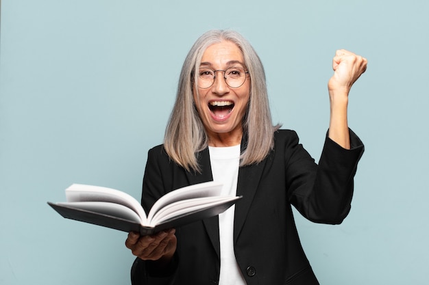 Jolie femme d'affaires senior avec un livre