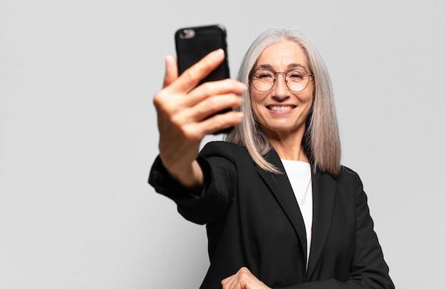 Jolie femme d'affaires senior avec un smartphone.