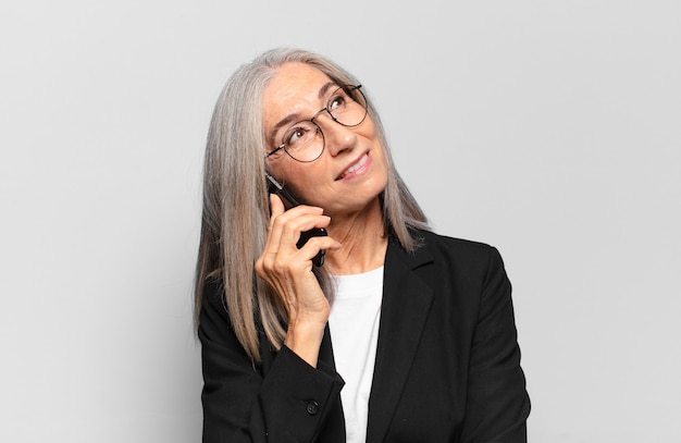 Jolie femme d'affaires senior avec un téléphone intelligent.