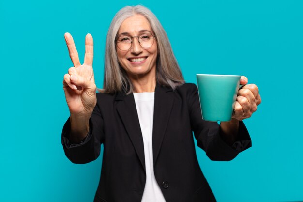 Jolie femme d'affaires supérieure avec une tasse de café