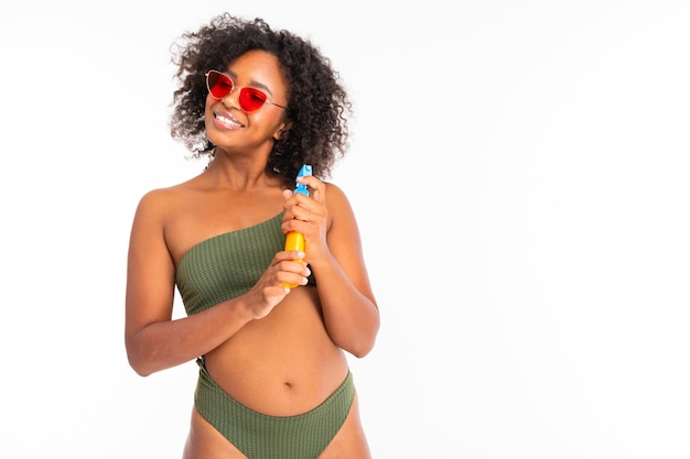 Photo jolie femme africaine en maillot de bain avec boîte de stérilisation et sourires isolés