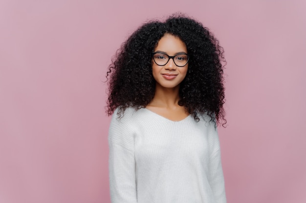 Jolie femme afro-américaine regarde à travers des lunettes transparentes