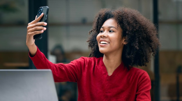 Jolie femme afro-américaine se fait selfie avec un téléphone portable