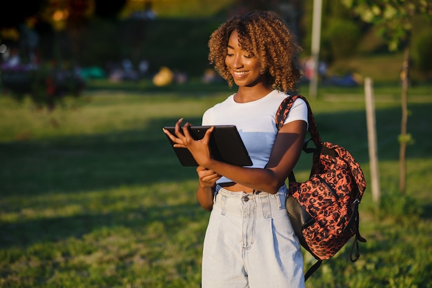 Jolie femme afro-américaine avec tablette au parc