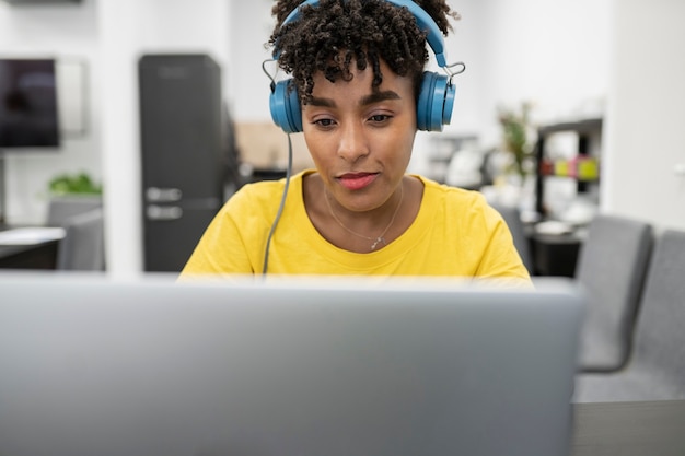 Jolie femme afro travaillant avec des écouteurs répondant aux clients