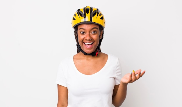 Jolie femme afro avec des tresses avec un casque de vélo