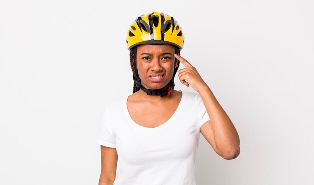 Jolie femme afro avec des tresses avec un casque de vélo