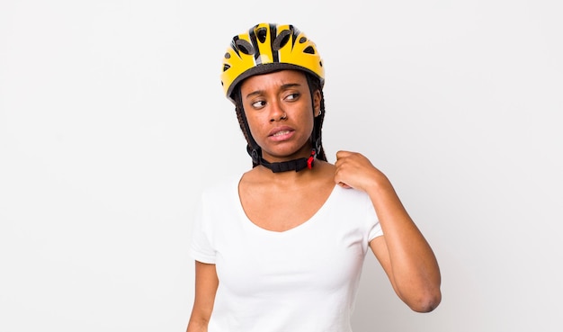 Jolie femme afro avec des tresses avec un casque de vélo