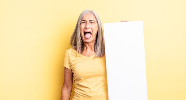 Jolie femme d'âge moyen criant agressivement, l'air très en colère. concept de toile vide