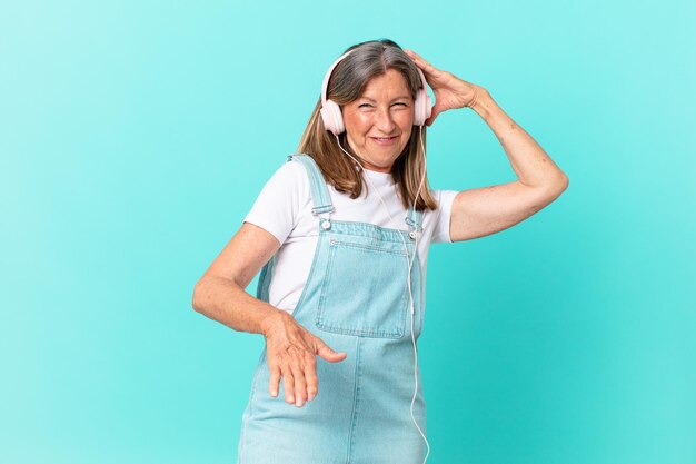 Jolie femme d'âge moyen écoutant de la musique avec un casque