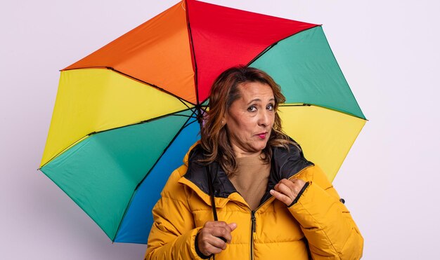 Jolie femme d'âge moyen qui a l'air arrogante, réussie, positive et fière. notion de parapluie