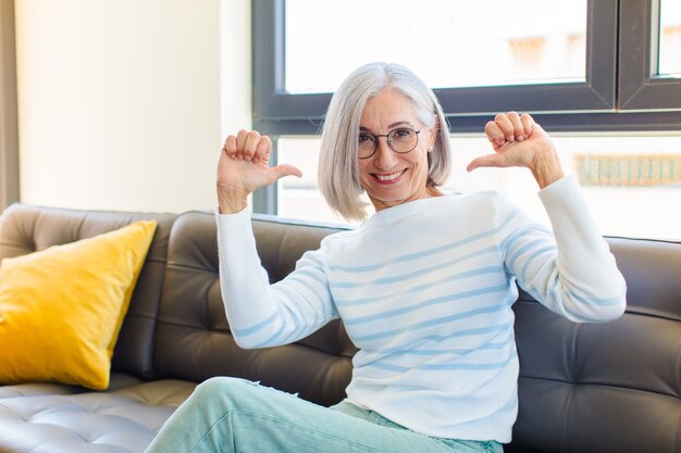 Jolie femme d'âge moyen se sentant fière, arrogante et confiante, l'air satisfaite et réussie, pointant vers soi