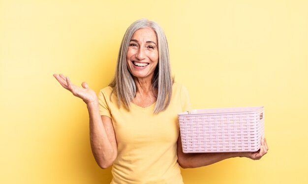 Jolie femme d'âge moyen se sentant heureuse, surprise de réaliser une solution ou une idée. concept de panier vide