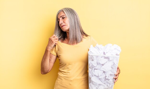 Jolie femme d'âge moyen se sentant stressée anxieuse fatiguée et frustrée concept d'échec des boules de papier