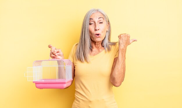 Jolie femme d'âge moyen semblant étonnée d'incrédulité. concept de cage ou de prison pour animaux de compagnie