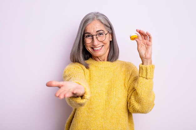 Jolie femme âgée souriante joyeusement avec amicale et offrant et montrant un concept. concept de lentilles de contact