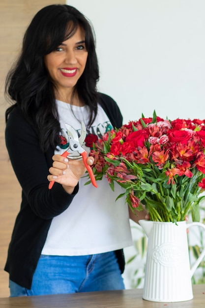 Jolie femme à l'aide de ciseaux pour couper les tiges de bouquets de fleurs