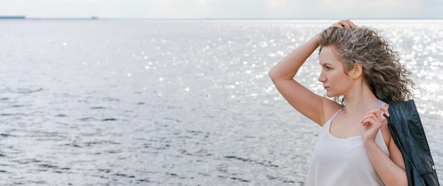 Jolie femme aime les promenades d'été le long de la promenade porte un t-shirt